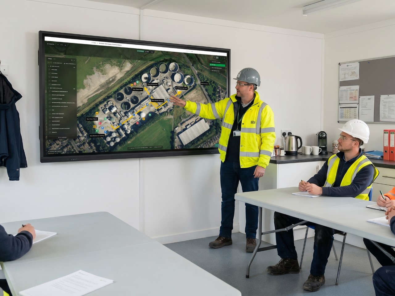 Photoreal 3D site induction shown on a tablet on a construction welfare desk.